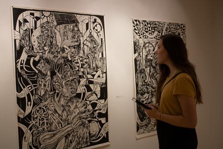 A guest view the work of artist Steve A. Prince in the Union Art Gallery during the show's opening event. - Photo by Abigail Aspinwall