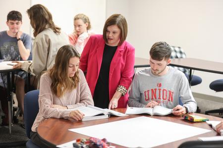 Mandy Cates, assistant professor of education, talks with students about a group project. - Photo by Kristi McMurry Woody