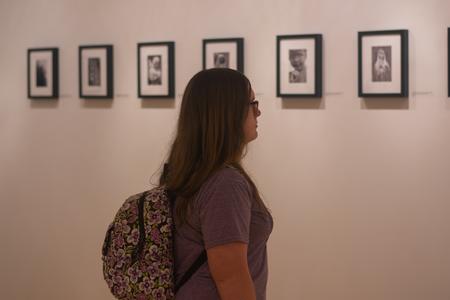 Students check out Steve Halla's photographs in the Union art gallery. - Photo by Faith Orr
