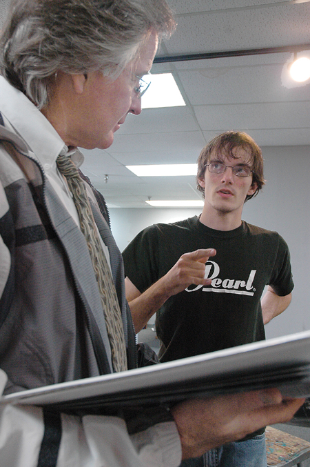 <i>C&C Photo Story:</i> Seeking advice from photojournalism instructor Jim Veneman, Tyler Malone brainstorms about how to arrange his photographs
for the symposium. - Photo by Kathleen Murray