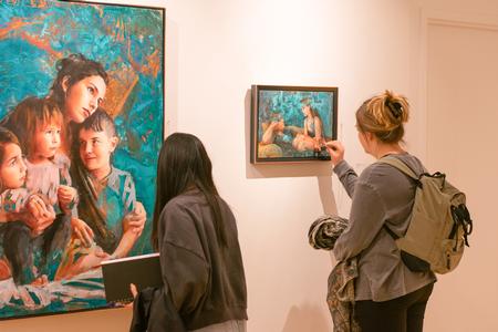 Students view an exhibit featuring the art of Elisabeth Marsch ('14) who specializes in portrait and figure painting on reacted copper panels. - Photo by Faith Orr
