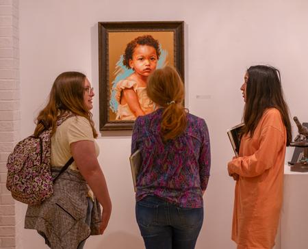 Students view an exhibit featuring the art of Elisabeth Marsch ('14) who specializes in portrait and figure painting on reacted copper panels. - Photo by Faith Orr