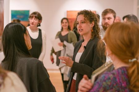 Elisabeth Marsch ('14) talks to students about her new art exhibit in the art gallery. - Photo by Faith Orr