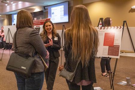 Chloe Thomas, senior art major, shares her poster presentation entitled "Revolutionizing the Title Sequence in Cinema" during the Scholarship Symposium. - Photo by Lyla Dietz