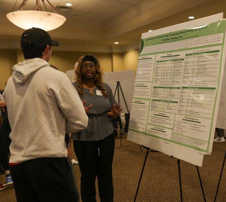 Cece Morton, senior chemistry major, shares her poster presentation entitled "Quantification of Pollutants from
Concentrated Animal Feeding Operations in the West Tennessee Area" for the Scholarship Symposium. - Photo by Suzanne Rhodes