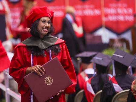 Joyce Skaria, PharmD graduate, smiles to her family and friends as she receives her diploma at spring graduation. - Photo by Suzanne Rhodes