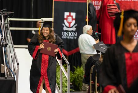 MacKenzie Pilgrim, social work graduate, smiles as she receives her diploma at spring graduation. - Photo by Kristi McMurry Woody
