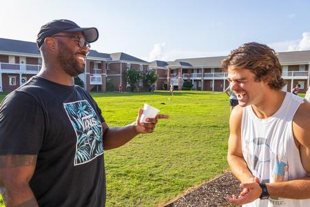 Residence director Kevin Morgan laughs with Mikie Veneable during the ResLife's Labor Day Block Party. - Photo by Abigail Aspinwall