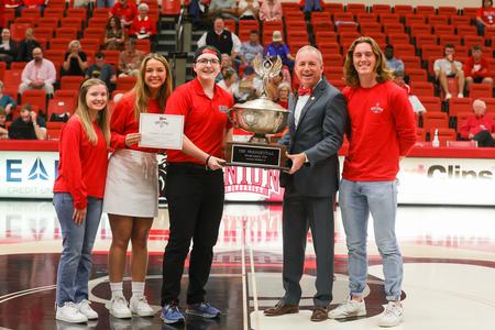 Students with the homecoming committee present Lambda Chi Alpha with the Homecoming Cup award during the homecoming basketball game. - Photo by Suzanne Rhodes
