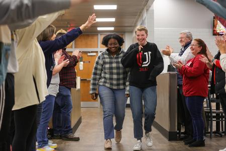 Students Brittany Simpson and Jessica Searl are greeted by faculty and staff members cheering on students during the bi-annual Food for Finals event. - Photo by Suzanne Rhodes
