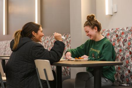 Students Julia Matteson and Laila Al-Hagaal laugh and enjoy a late-night breakfast during the bi-annual Food for Finals event. - Photo by Suzanne Rhodes
