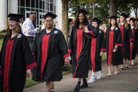 Iandra Gabrielle Defreitas, a social work major from Clarksville, Tenn., waves at the camera as she and fellow classmates process into Spring Graduation. - Photo by Kristi McMurry Woody