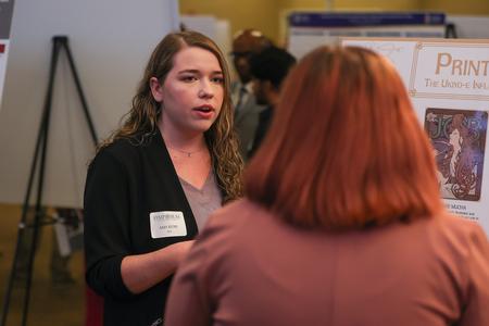 Art major Amy Kuhl explains her poster presentation entitled "Prints and Posters: The Ukiyo-e Influence on Alphonse Mucha's Aesthetic" at the 2023 UUSS. - Photo by Eli Creasy