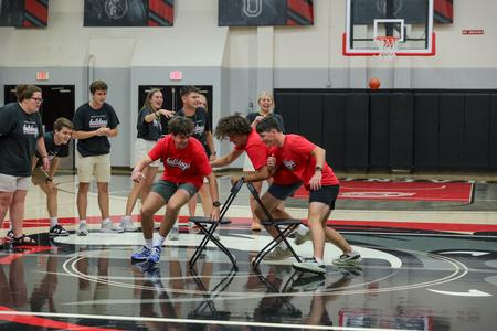 Three new students compete in a game of musical chairs to win points for their teams during Welcome Week. - Photo by Karley Hathcock