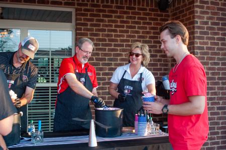 8/19/23 - Executive Council members Bryan Carrier, John Netland, and Catherine Kwasigroh serve ice cream at President Oliver's house during Welcome Week.  - Lauren Steed