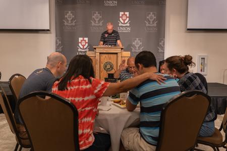 President Oliver leads families in prayer for their students at the President's Brunch during Family Weekend. - Photo by Lauren Steed