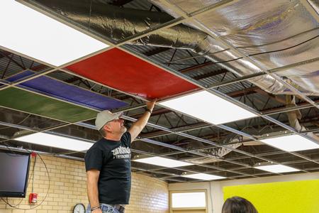 Softball Assistant Coach Bryan Wallen inserts ceiling tiles in the cafeteria at Nova Early Learning Center during Campus and Community Day. - Photo by Karley Hathcock