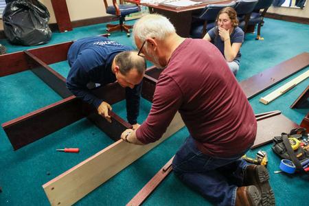 Professors Justin Wainscott and Mark Dubis assemble furniture at West Jackson Baptist Church during Campus and Community Day. - Photo by Karley Hathcock