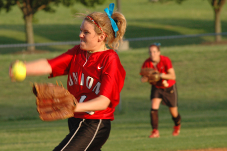 Junior pitcher Jackie Cliff (12) makes a pitcher during one of Union's game as senior left fielder Allison Shein looks on. - Photo by Jonathan Blair