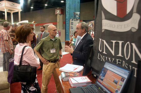 Union President David S. Dockery talks to Jonathan Newman ('90) and his wife Jeni at the Union booth during the Southern Baptist Convention. - Photo by Brad Moore