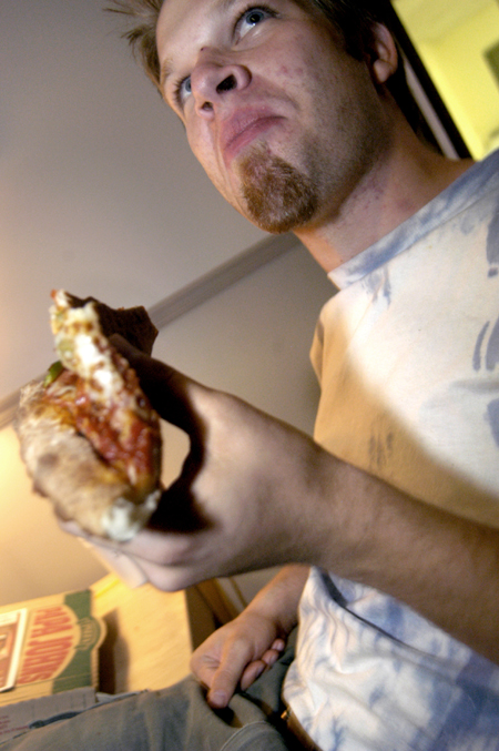Senior Jay Gunn digs in on some pizza during finals week. - Photo by Jonathan Blair