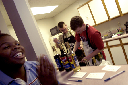 Sophomore Ron Holley and Freshman Alvin Jeffrey run an impromptu coffee bar in McAfee commons during finals week.  Ray Jones shows his enthusiasm for the project. - Photo by Jonathan Blair