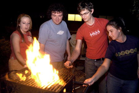 Freshmen Molly Sills, Josh Clarke, Ronald Long, and Senior Audra Funderburk get the grill fired up outside the McAfee commons during finals week. - Photo by Jonathan Blair