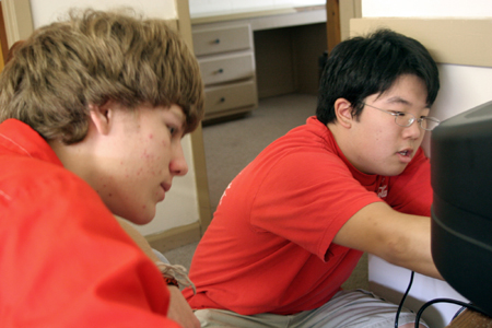 New roommates Lukas Burke of Jackson, Tenn. & Jonathan Choi of Charlotte, N.C. hook up the television in their dorm room during Freshman Move-In Day. - Photo by Kyle Kurlick