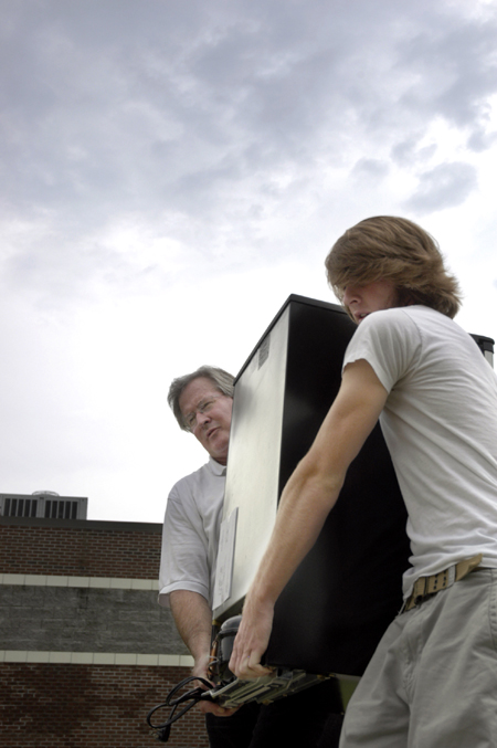 Jim Veneman, director of visual communications, helps his son Nathan Veneman move into the dorms during Freshman Move-In Day. - Photo by Kathleen Murray