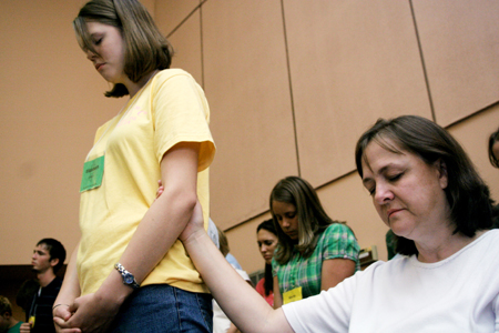 Debbie Spence of Mount Olive, Ala. holds on to her daughter Elizabeth during the worship service held on the first day of New Student Orientation. - Photo by Kyle Kurlick