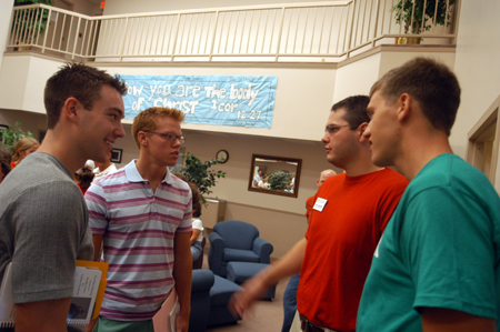 Enrollment Counselor Chad Cossiboom and Junior Chris Arnold talk with Freshmen Kirk Johnston and Mark Inman after they sign in at McAfee Commons on Freshman Move-In Day. - Photo by Brad Moore