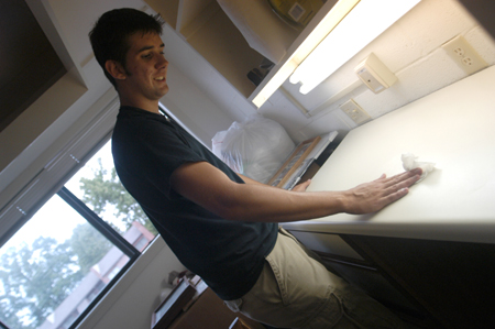 Freshman Josh Hays of Murfreesboro, Tenn. cleans off his desk before unpacking on Freshman Move-In Day. - Photo by Brad Moore