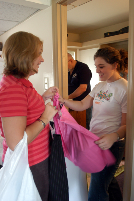 Kelly Northam of Houston, Tex. takes a look at a skirt with one of her roommates' mothers while her father Bruce finishes a project in her room. - Photo by Heather Phillips