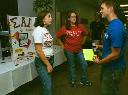 Sigma Alpha Iota members Sarah Thompson and Rachel Sebby talk to a Freshman about their music organization at the Campus Life Fair during New Student Orientation 2002. - Photo by Kristen Hiller