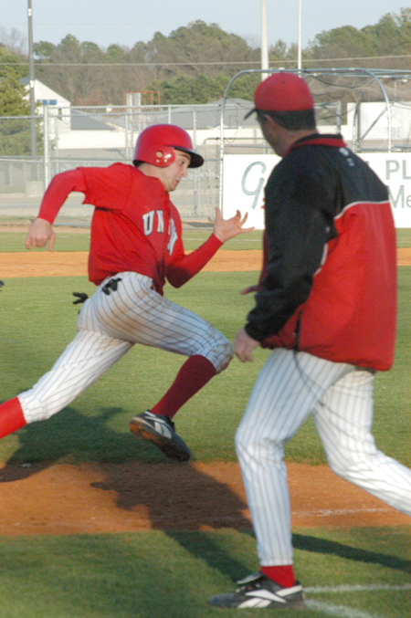 Sophomore outfielder Tyler Porter gets waived home by Head Coach Andy Rushing. - Photo by Steven Aldridge