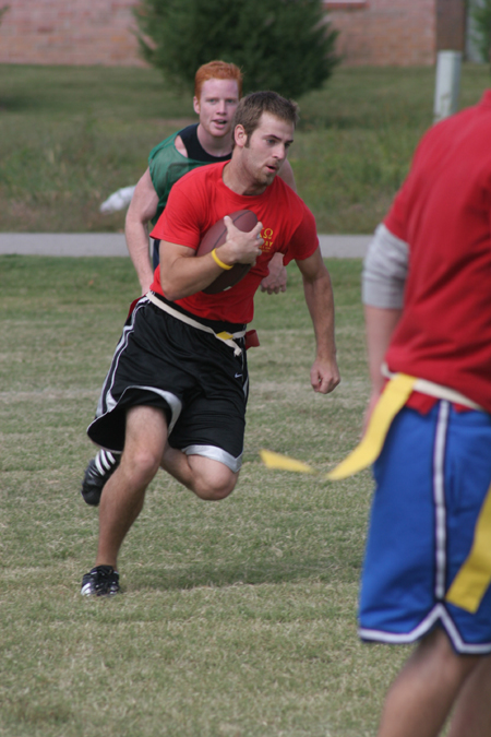 Freshman Brian Bodnarchuk carries the ball during a Family Weekend flag football game.  Sophomore Jack Smothers chases him down in the background. - Photo by Kyle Kurlick