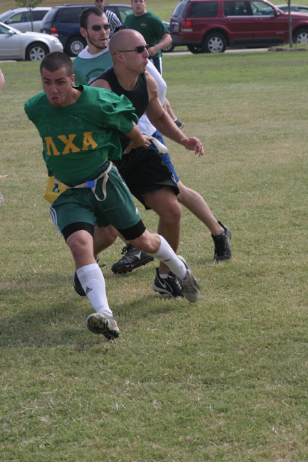 Junior Bryan Spillman tries to break away as Senior Josh Willhite and  Sophomore Austin Clark keep an eye out for the ball during Family Weekend flag football action. - Photo by Kyle Kurlick