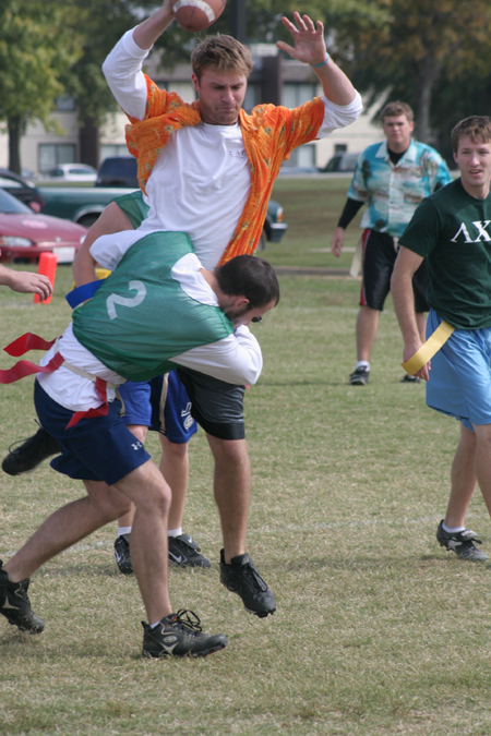 Sophomore Austin Clark tries to bring down Chad Farneth as Senior Derek Carson looks on during a Family Weekend flag football game. - Photo by Kyle Kurlick