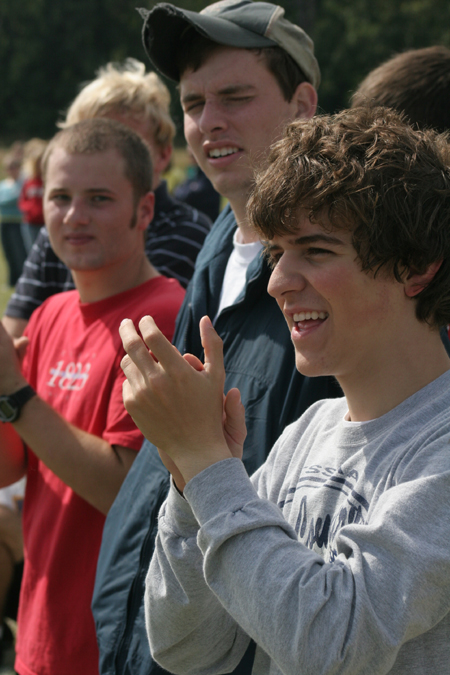 Freshman Matt Elia and others cheer from the sidelines during a Family Weekend flag football game. - Photo by Kyle Kurlick