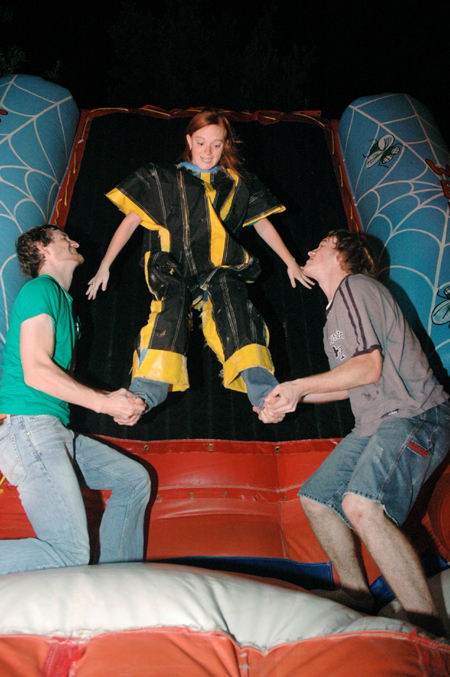 Sophomore Ronald Long and Freshman Dustin Nelson give Sophomore Kinsey Bolinger a boost onto the inflatable velcro wall during Fallapalooza. - Photo by Brad Moore