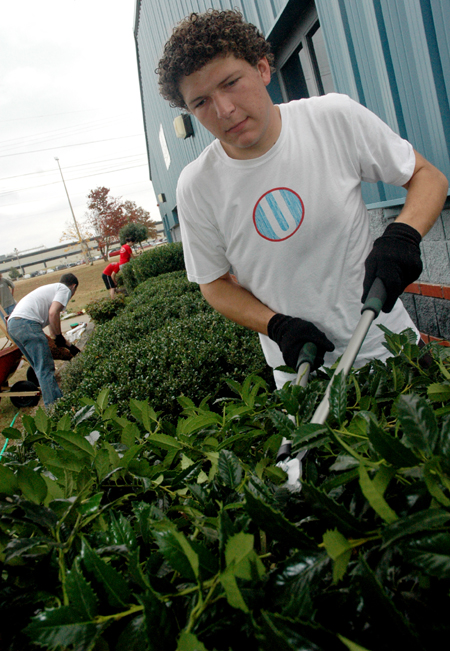 Sophomore Blake Waggoner trims shrubbery at the Boys and Girls Club of Jackson during the Day of Remembrance. - Photo by Brad Moore