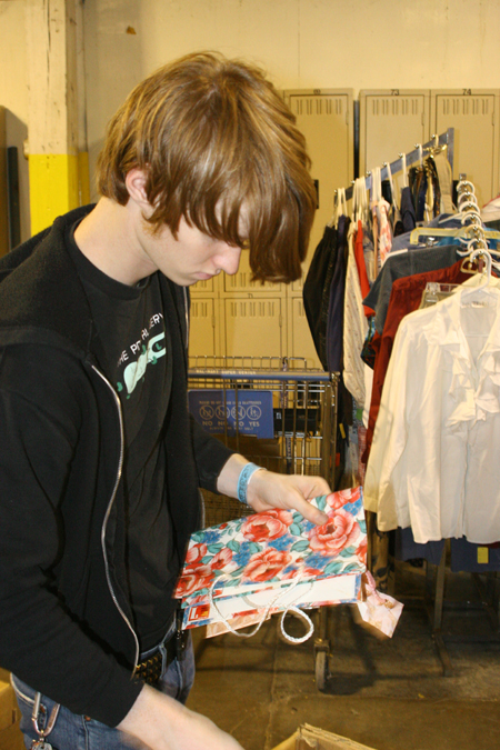 Sophomore Andrew Gray separated clothing at RIFA during Alpha Psi Omega's Day of Remembrance service project. - Photo by Derek Ownby