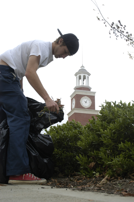 Freshman Ben Trail weeded flower beds on campus during Day of Remembrance. - Photo by Kathleen Murray