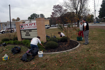 Bev Vos, director of promotional strategies, supervised a landscaping project at Pope Elementary School during Day of Remembrance. - Photo by Morris Abernathy