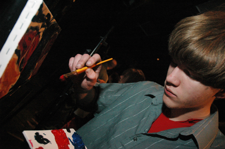 Freshman Lukas Burke paints as random music plays in the background during an interlude at Cafe Bongo. - Photo by Brad Moore
