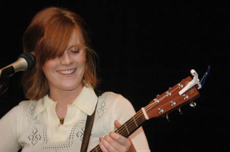 Senior Alice Calvery smiles as she serenades the Cafe Bongo audience with a song. - Photo by Brad Moore