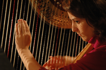 Senior Joy Ledden plucks the strings of her harp during Cafe Bongo. - Photo by Brad Moore