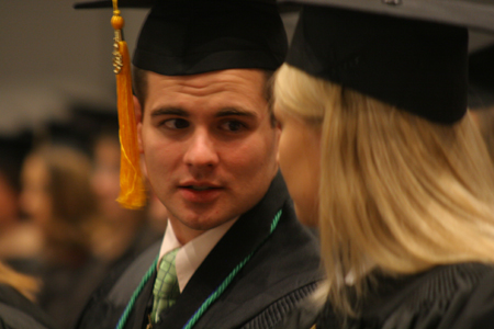 Ian Ellis talks with a fellow graduate after receiving his bachelor of science degree in athletic training during fall graduation. - Photo by Kyle Kurlick