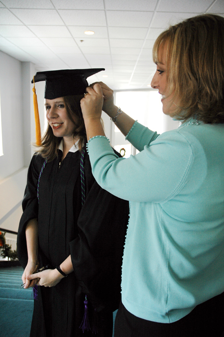Learning Foundations Graduate Jennifer Sampson receives assistance with her cap before joining fellow graduates at fall graduation. - Photo by Brad Moore