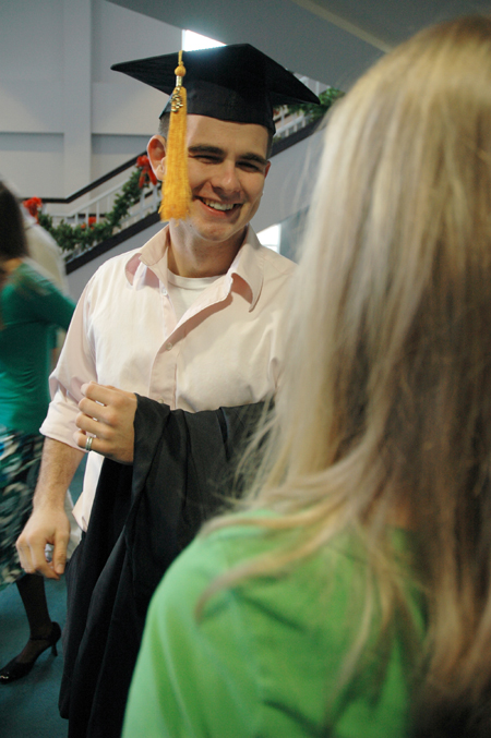 Athletic Training Graduate Ian Ellis spent a moment of time with his fiance before changing into his gown preceding the fall graduation ceremony. - Photo by Brad Moore